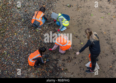 Strand Reiniger herauf Plastik und Müll vom Strand oder Küste bei Ebbe auf der Themse im Zentrum von London. Stockfoto