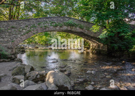 Landschaft Fotografie. Alte steinerne Brücke über den Gebirgsbach in ländlichen Gemeinden, North West England. Nachmittag licht und schatten Ruhe der Landschaft. Stockfoto