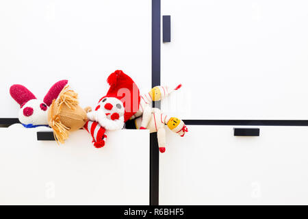 Vorderansicht des lustigen vintage Kinder Spielzeug in einen Schrank Schublade. Sortiment besteht aus einem Clown, ein Eichhörnchen, ein Häschen und Puppen. Stockfoto