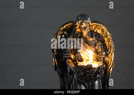 Silber Engel Statue Holding eine brennende Kerze in Nahaufnahme, Weihnachten und spirituellen Tradition Stockfoto