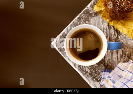 Chocolate Brownie bestreut mit Kakao und Kokosnuss im Hintergrund mit einem kaffeebecher an der Ecke einen Tisch in der Nähe eines Fensters. Foto Stockfoto