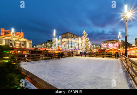 Traditionelle Straßenmarkt und Eislaufbahn im Marktplatz von Katowice, Polen zu Weihnachten. Stockfoto