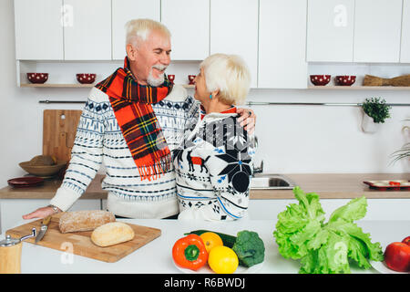 Senior paar Kochen gesund essen und an jedem anderen lächelnd an Küche Stockfoto