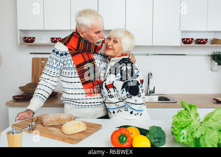 Senior paar Kochen gesund essen und an jedem anderen lächelnd an Küche Stockfoto