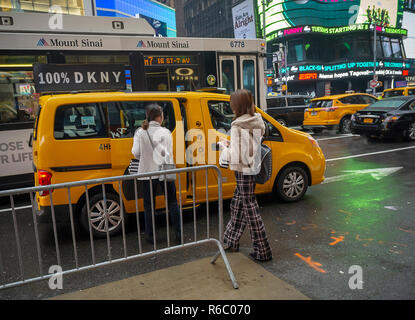 Touristen geben Sie ein Taxi am Times Square in New York auf/Sonntag, 2. Dezember 2018. (© Richard B. Levine) Stockfoto