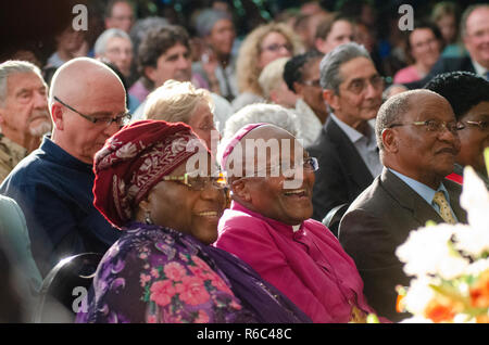 Erzbischof Desmond Tutu und Frau Lea einen hellen Moment während einer Trauerfeier der ehemalige südafrikanische Präsident Nelson Mandela auf der Nelson Mandela Foundation, in Houghton, Johannesburg, Südafrika, am 9. Dezember 2013. Die Elder statesman gestorben Donnerstag, 5. Dezember 2013. Sänger Peter Gabriel sitzt direkt hinter Tutu und Achmat Dangor, ehemaliger Leiter der Nelson Mandela Stiftung ist 2. rechts von Tutu gesehen. Foto: Eva-Lotta Jansson Stockfoto