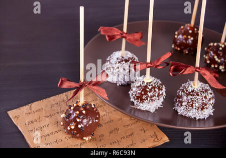 Verschiedene Kuchen Pops mit dunkler Schokolade auf einen hölzernen Tisch dekoriert Stockfoto