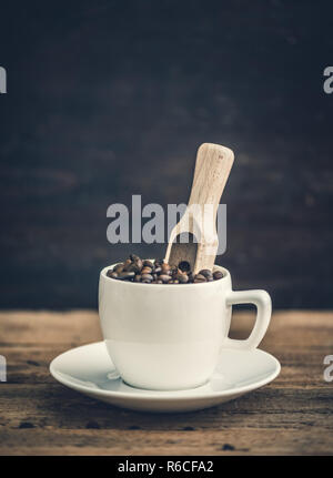 Weiße Keramik Tasse voll von gerösteten Kaffeebohnen Stockfoto