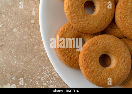 Top in der Nähe von Coconut anzeigen Cookies auf einer weißen Platte auf einem Marmor Zähler nach oben. Stockfoto