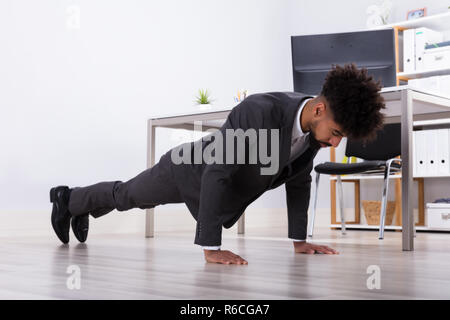 Unternehmer tun Push Up im Büro Stockfoto