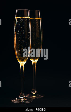 Zwei Gläser Champagner in voller Größe auf Schwarz elegante Hintergrund. Feier Konzept. Stockfoto