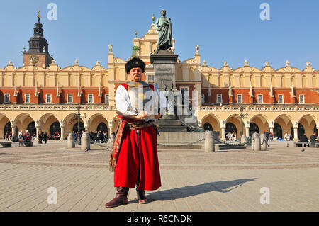 Tuchhallen (Sukiennice) und der Mensch im Alten Kostüm auf Marktplatz in Krakau, Polen Stockfoto