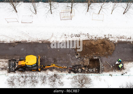 Oben Ansicht der Arbeitnehmer und der Traktor graben Straße Stockfoto