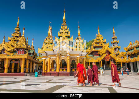 Anfänger buddhistische Mönche gehen Um die Shwedagon Paya die Heiligen goldenen buddhistischen Pagode in Yangon, Myanmar Stockfoto