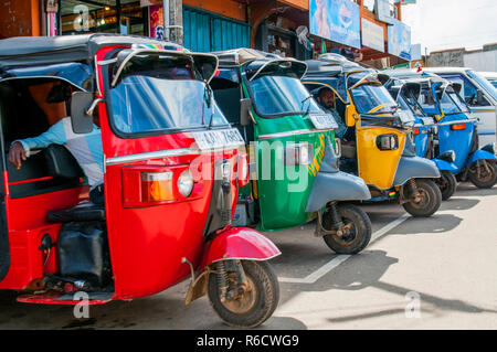 Reihe der Rote, Grüne, Gelbe und Blaue leere Tuk-Tuks wartet auf Passagiere in Sri Lanka Tuk-Tuk ist eine beliebte asiatische Transport Taxi Stockfoto