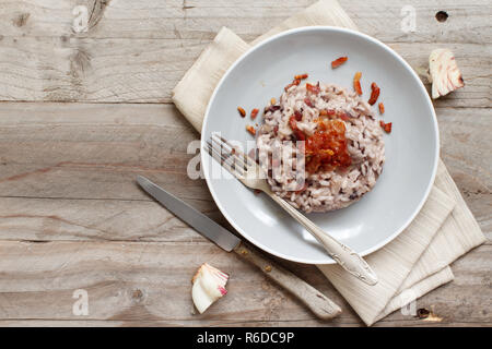 Risotto mit rotem Radicchio und knusprigem Speck (Speck) Stockfoto