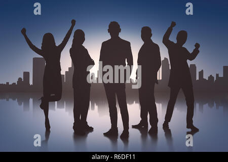 Silhouette von Angeregten Geschäftsleute mit Stadtbild Stockfoto