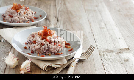 Risotto mit rotem Radicchio und knusprigem Speck (Speck) Stockfoto