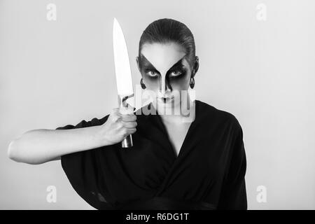 Schwere Frau, professionelle Geisha Make-up, in schwarzen Kimono mit großer Küche Messer an Kamera suchen, Schwarzweiß Stockfoto