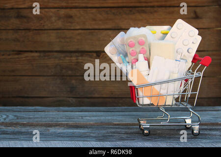 Warenkorb mit Medikamenten auf alten Holz- Hintergrund. Stockfoto