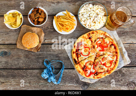 Fast food, Maßband auf alten Holz- Hintergrund. Konzept der Junk-Essen. Getönten Bild. Ansicht von oben. Stockfoto