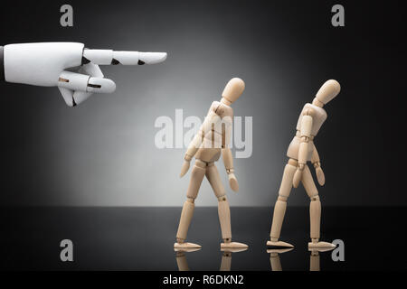 Robot Hand geben Richtung zu zwei Mannequins Stockfoto