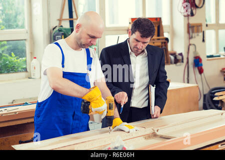 Chef und Arbeitnehmer in einer Schreinerei Stockfoto