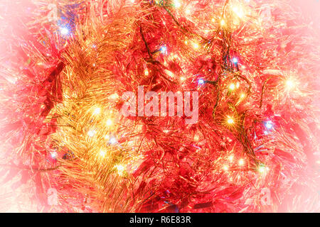 Abstrakt rot und goldenen Hintergrund mit Weihnachtsbeleuchtung und Dekoration. Stockfoto
