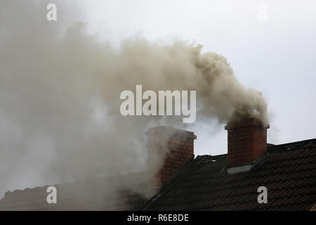 Rauch aus dem Schornstein eines Hauses getankt mit Kohle Stockfoto