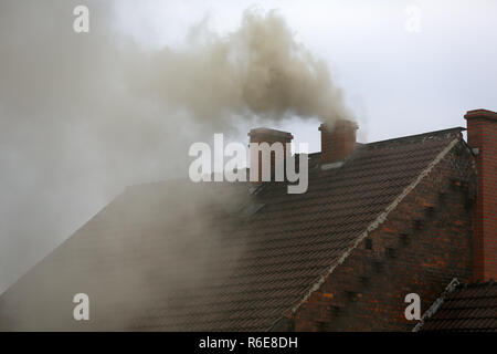 Rauch aus dem Schornstein eines Hauses getankt mit Kohle Stockfoto