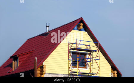 Gelbe siding Montage auf der zweiten Etage Landhaus aus Holz- Protokolle Stockfoto