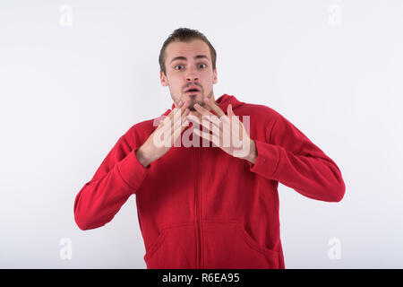 Studio shot Junger bärtiger Mann schaut erschrocken und entsetzt agai Stockfoto