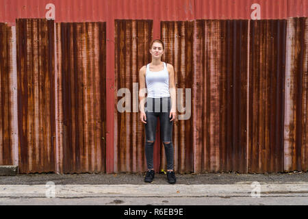 Junge schöne Mädchen im Teenageralter, gegen alten rostigen Blech wa Stockfoto