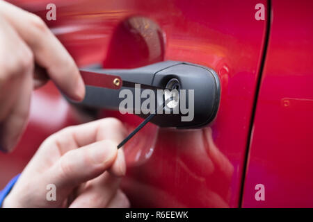 Menschliche Hand Öffnen der Autotür mit Lockpicker Stockfoto