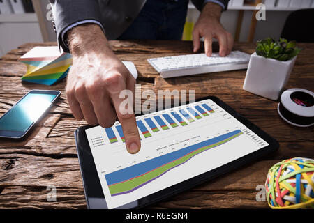 Unternehmer mit digitalen Tablette mit der Grafik auf dem Bildschirm Stockfoto