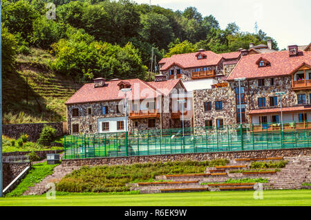 Dilijan, Armenien, August 24,2018: moderne Ferienhäuser für Studenten, mit geschnitzten Holzbalkonen im ethnischen Stil und komfortabel Tennisplätze im Intern Stockfoto