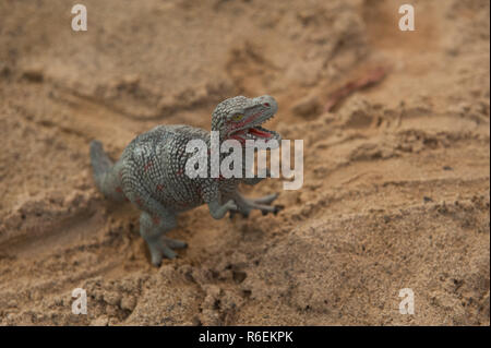 Ein Dinosaurier Spielzeug auf dem Sand Stockfoto