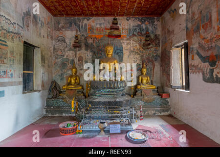 Sitzender Buddha Statue mit Wandmalereien im Hintergrund, Wat Pak Huak, Luang Prabang, Laos, Indochina, Südostasien, Asien Stockfoto