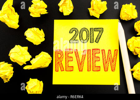 Handschriftlichen Text anzeigen 2017 überprüfen. Business Konzept schreiben für jährlichen zusammenfassenden Bericht über die Kurznotiz Papier auf dem schwarzen Hintergrund geschrieben. Gefaltete gelbe Papiere auf dem Hintergrund Stockfoto
