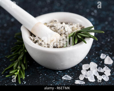 Meersalz duftende Kräuter Rosmarin auf dunkelblauem Hintergrund Stockfoto