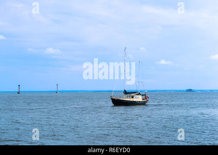 8. September 2018, der Region Kaliningrad, Russland, schwarze und weiße Yacht auf dem Wasser, Yacht mit abgesenktem Segel Stockfoto