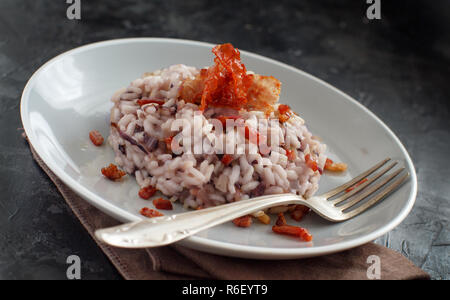 Risotto mit rotem Radicchio und knusprigem Speck (Speck) Stockfoto