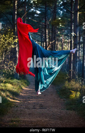 Schöne, junge Frau levitierten in Wäldern. Fliegen im Traum. Das Fehlen der Schwerkraft. Konzept der Magie, Wunderland und Märchen im Wald. Stockfoto