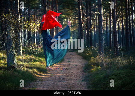 Schöne, junge Frau levitierten in Wäldern. Fliegen im Traum. Das Fehlen der Schwerkraft. Konzept der Magie, Wunderland und Märchen im Wald. Stockfoto