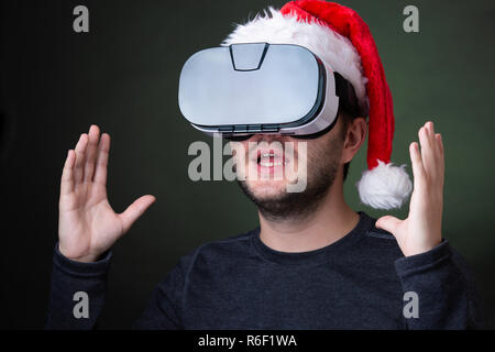 Foto von Mann in Santa's Gap und Gläser der virtuellen Realität Stockfoto