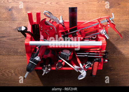 Verschiedene Worktools in Toolbox auf hölzernen Schreibtisch Stockfoto