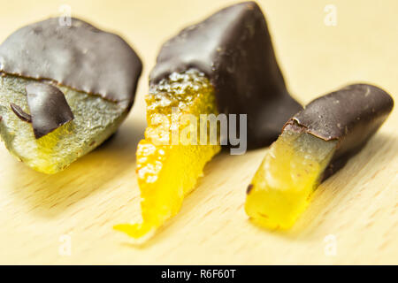 Leckere dunkle Schokolade Pralinen mit Birne, Orange und Ingwer auf einem hölzernen Schneidebrett Stockfoto