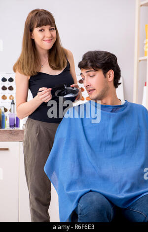Junge attracrive Mann Besuch weiblicher Friseur Stockfoto