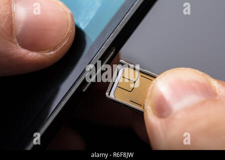 Einsetzen einer SIM-Karte in ein Handy Stockfoto
