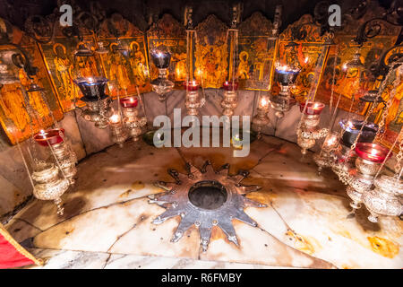 Ein silberner Stern markiert den traditionellen Ort der Geburt Jesu in Bethlehem in einer Grotte unterhalb der Kirche der Geburt, Palästina Stockfoto